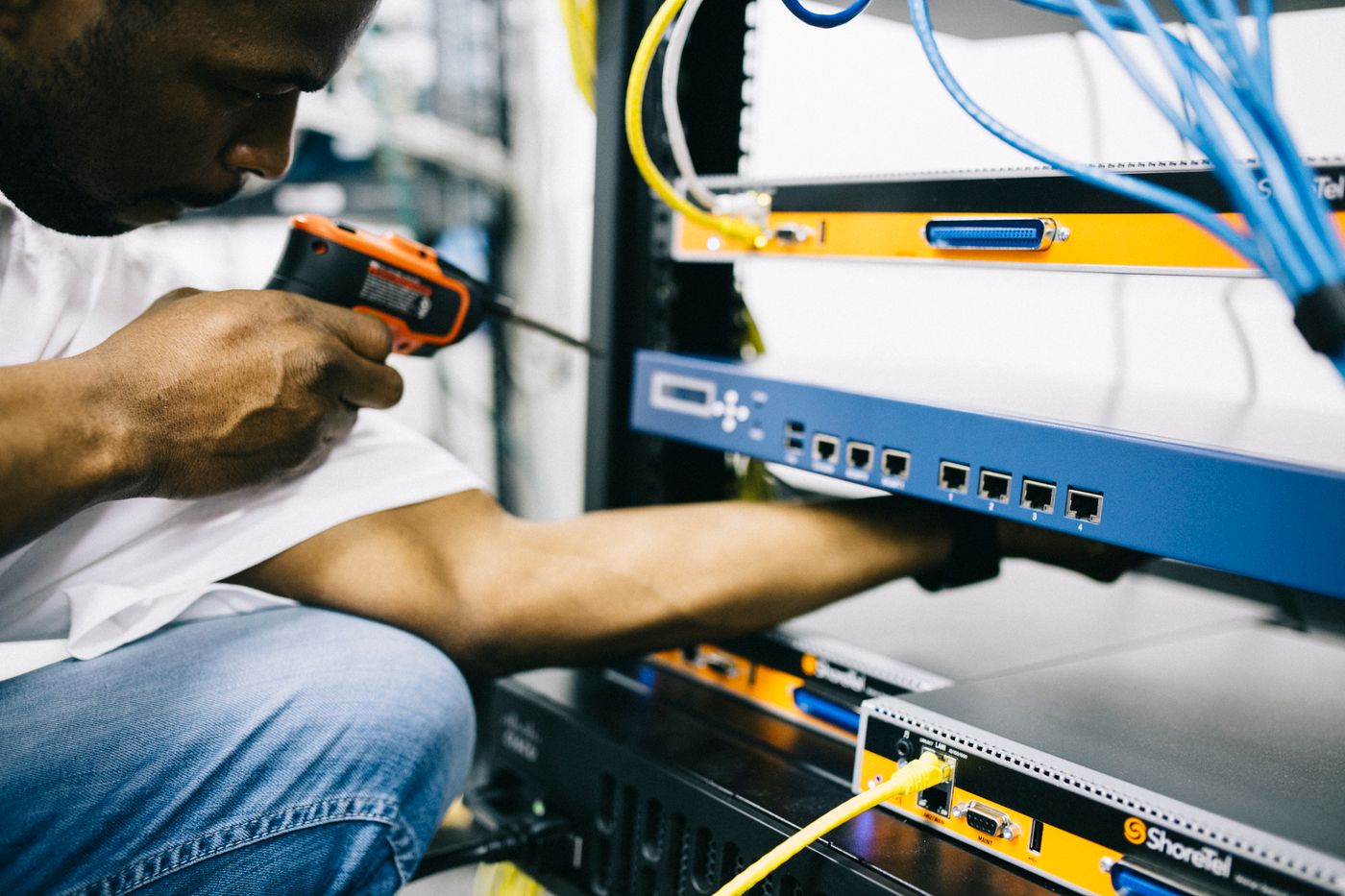 Technician installing network equipment in a server rack